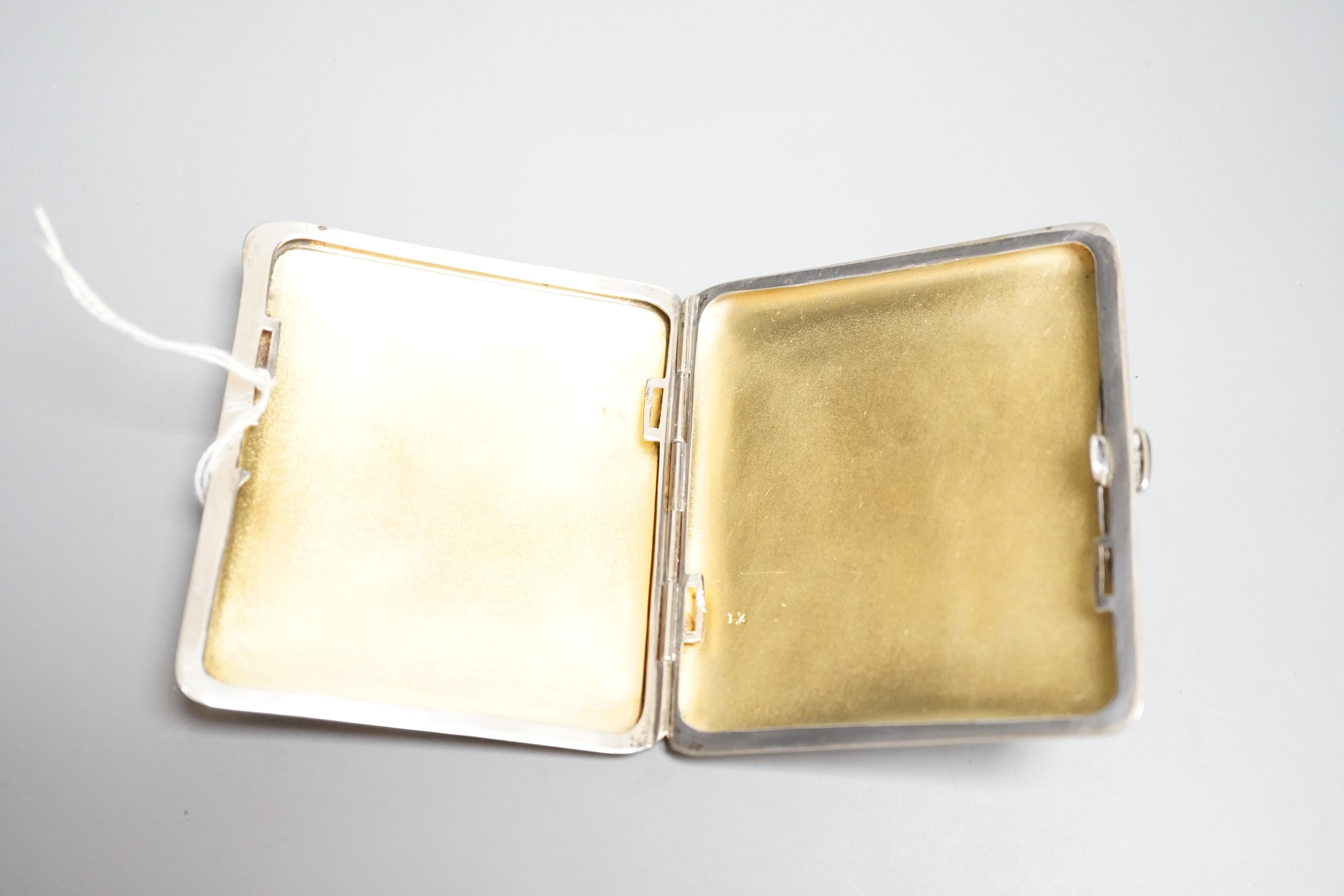 A Continental silver plated cigarette case, early 20th century, lid with erotic enamel scene of naked lady standing in front of a cheval mirror, gilt interior stamped ALPARP, height 8.5cms.